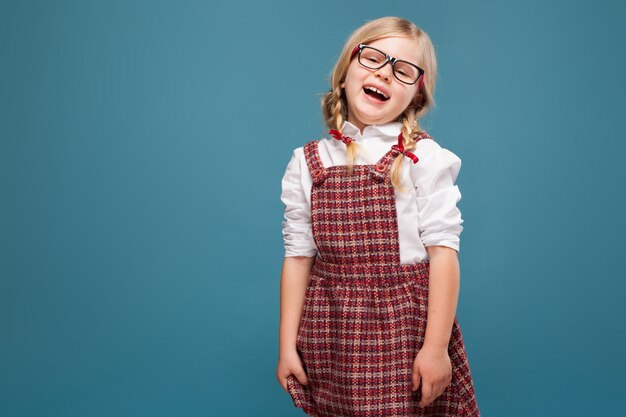 Niña linda en vestido rojo, camisa blanca y gafas