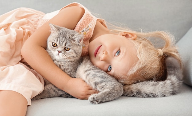 Niña con lindo gato en casa