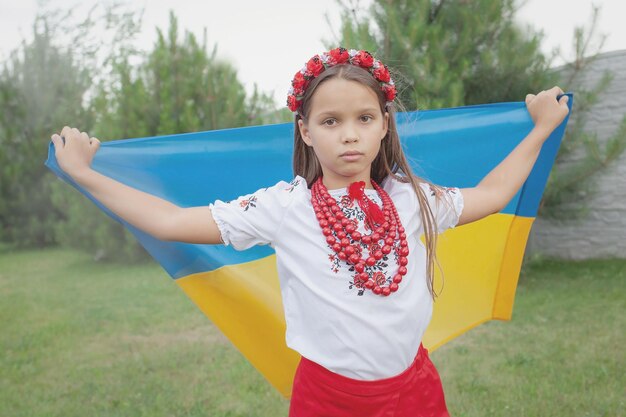 La niña lleva la bandera en sus manos.