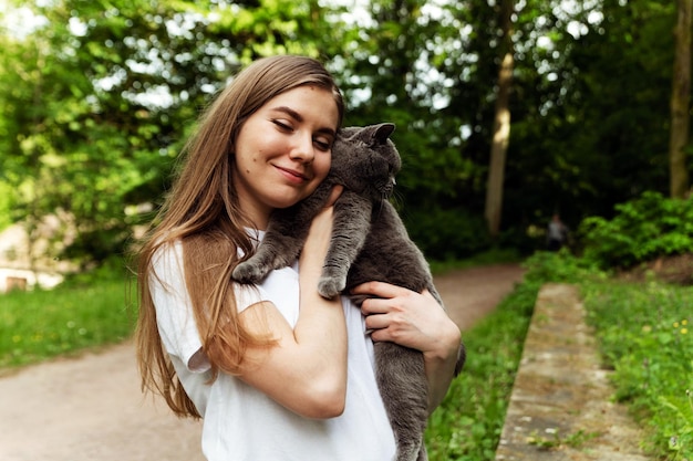 Foto la niña lleva el gato en una mano el gato en la otra llevando amor por un gato la niña abraza