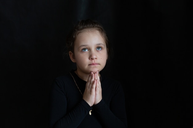 Foto niña llorando triste reza vestida de negro