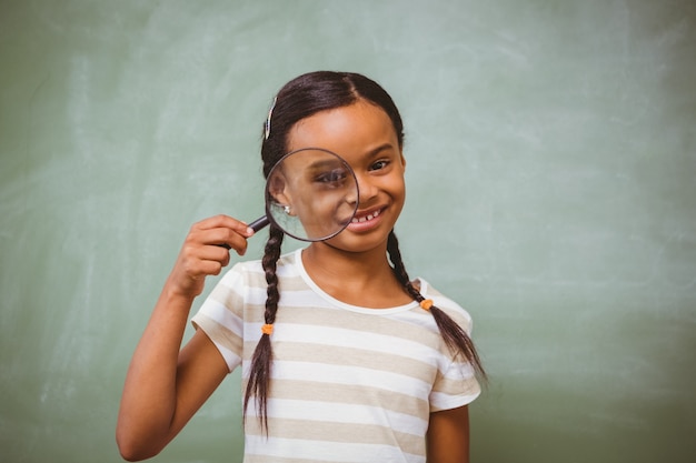 Niña con lupa en el aula