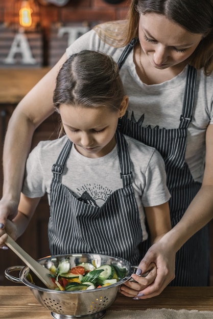 Niña y madre haciendo ensalada