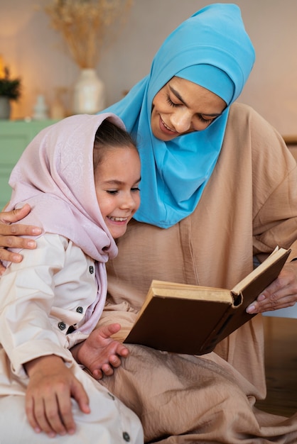 Foto niña y madre leyendo juntas plano medio