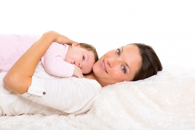 Foto niña y madre tumbados felices juntos en piel blanca