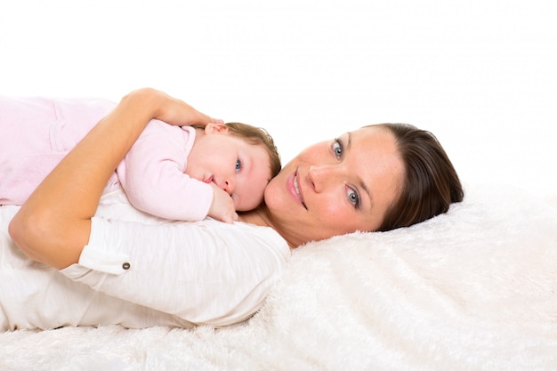 Niña y madre tumbados felices juntos en piel blanca