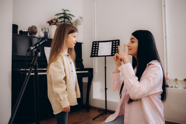 una niña con un maestro en clases de canto