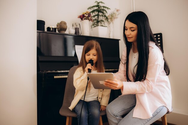 una niña con un maestro en clases de canto