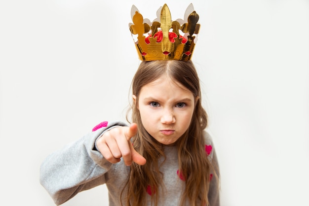 Niña malvada con una corona sobre un blanco