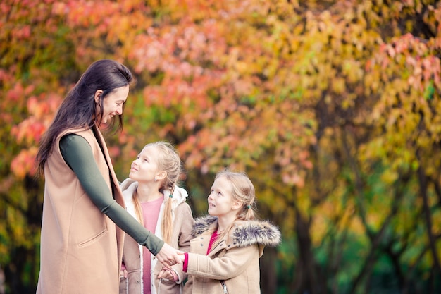 Niña con mamá al aire libre en el parque en día de otoño