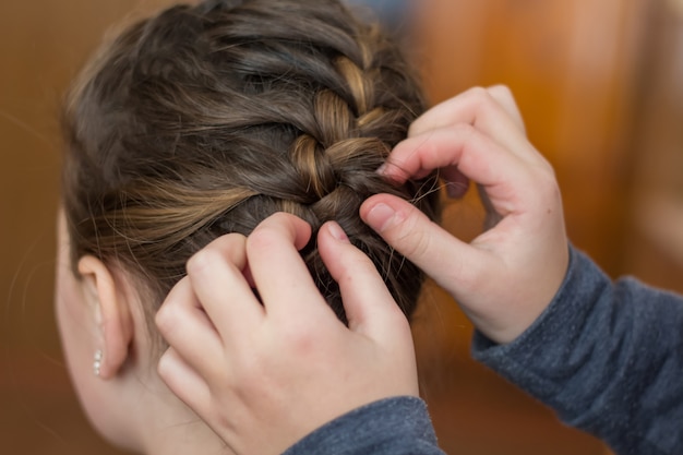 Niña mamá hace un pelo o una niña en una peluquería