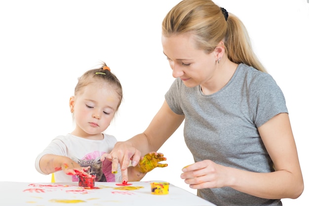 Niña con mamá jugando y jugando con pinturas de colores