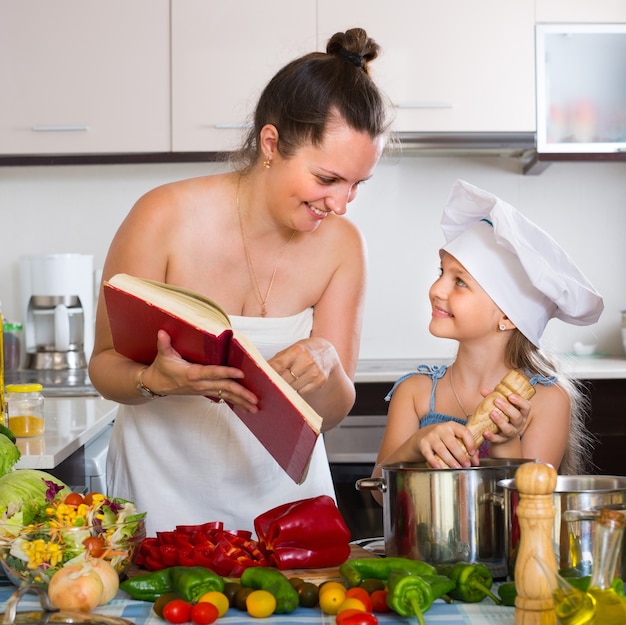 Niña y mamá con libro de cocina