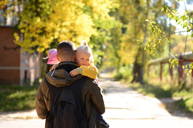 La niña en manos del padre yace sobre su hombro.