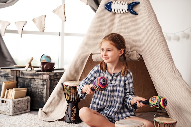 Niña con maracas y tambores djembe