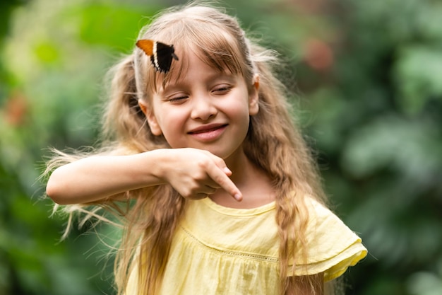 Niña con mariposa en la mano.