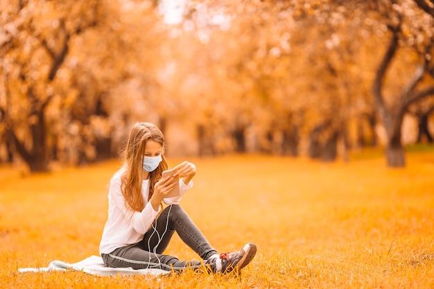 Niña con una máscara protectora al aire libre