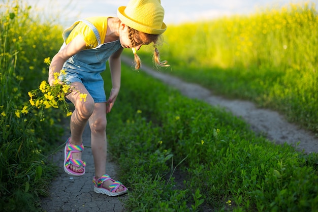 Niña mata mosquitos en sus manos y pies. El niño se da palmadas en el cuerpo, se rasca los lugares de las picaduras, protección contra las picaduras de insectos, repelente seguro para los niños. Recreación al aire libre, contra las alergias.