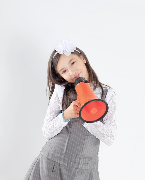 Niña con un megáfono rojo aislado sobre fondo blanco.