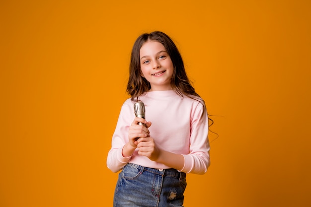 niña con micrófono sonriendo cantando