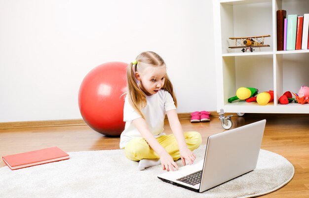 Una niña mira la computadora. El niño está sorprendido.