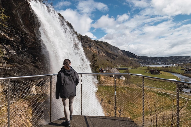 Foto la niña está mirando el agua que cae de una cascada.