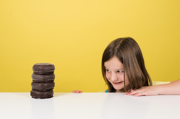 Niña mirando con envidia un montón de donas