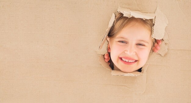 Niña mirando straigt de caja de cartón