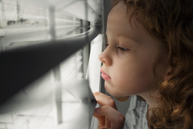 Niña mirando por la ventana