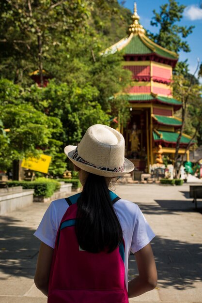 Foto niña con mochila entrando en el santuario quan yin en el templo tham seua