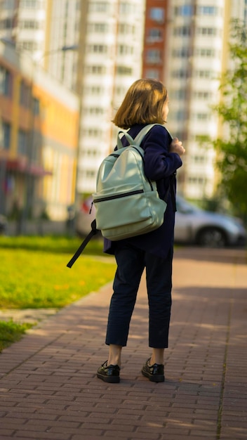 Una niña una mochila va a la escuela.