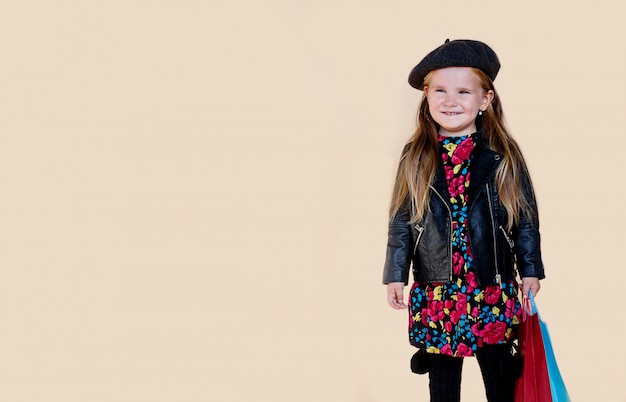 Foto niña de moda con pelo largo en chaqueta de cuero y boina