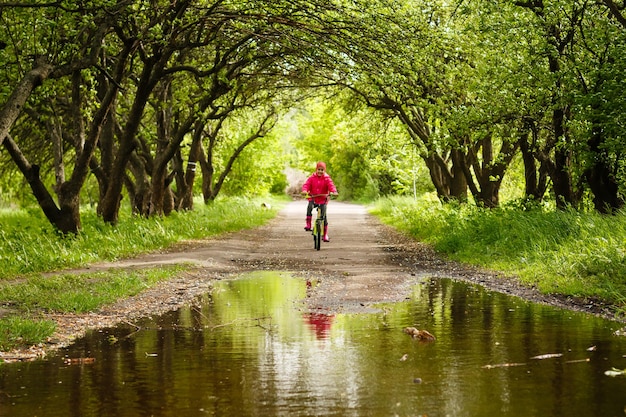 niña montando bicicleta en un charco de agua