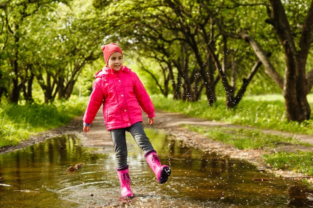 niña montando bicicleta en un charco de agua