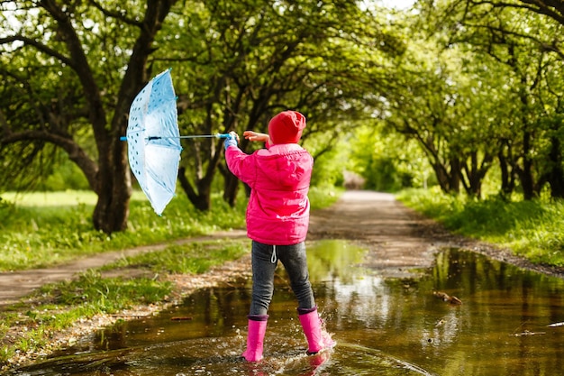 Foto niña montando bicicleta en un charco de agua