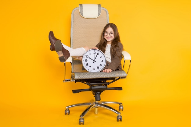 Niña morena con relojes en silla