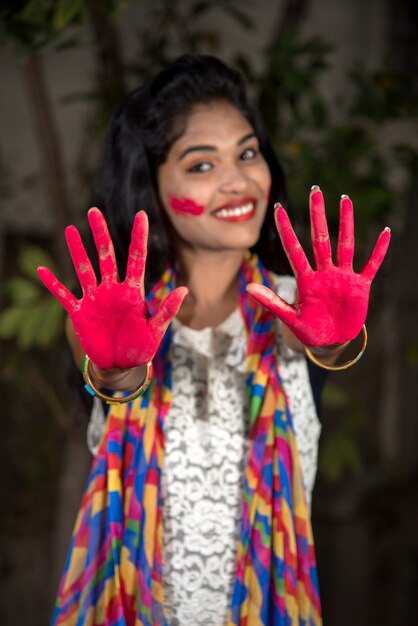 Niña mostrando coloridas palmeras y celebrando Holi con salpicaduras de color