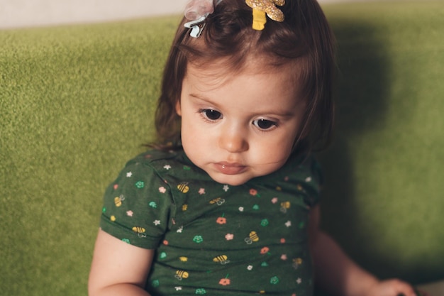 Niña mostrando sus dientes blancos mientras posa mirando a la cámara y sosteniendo un pepino Casa pequeña Familia feliz Retrato de primer plano Vida infantil Cara de belleza