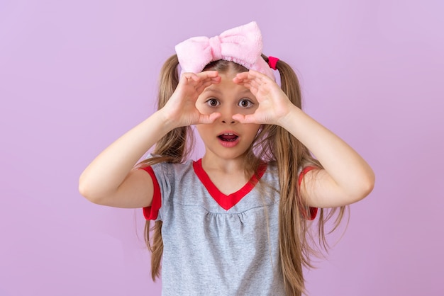 Una niña muestra un par de binoculares imaginarios.