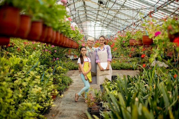 Niña, mujer joven y mujer mayor en el jardín de flores