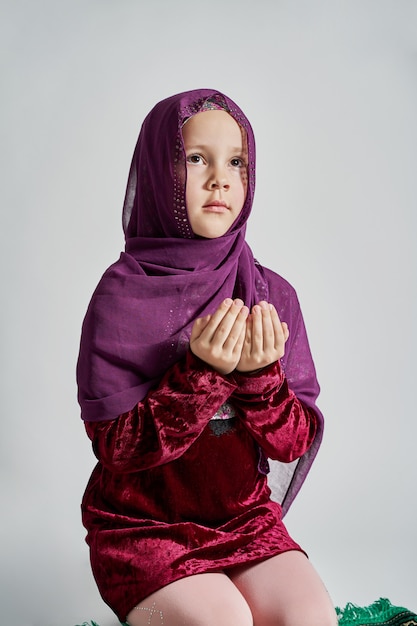 Foto una niña musulmana en un hijab reza