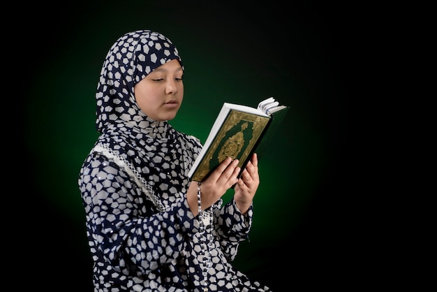 Niña musulmana leyendo el libro sagrado del Corán