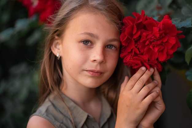 Niña muy hermosa cerca de las rosas