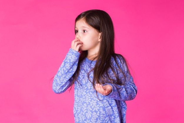 Niña muy linda en la pared rosa