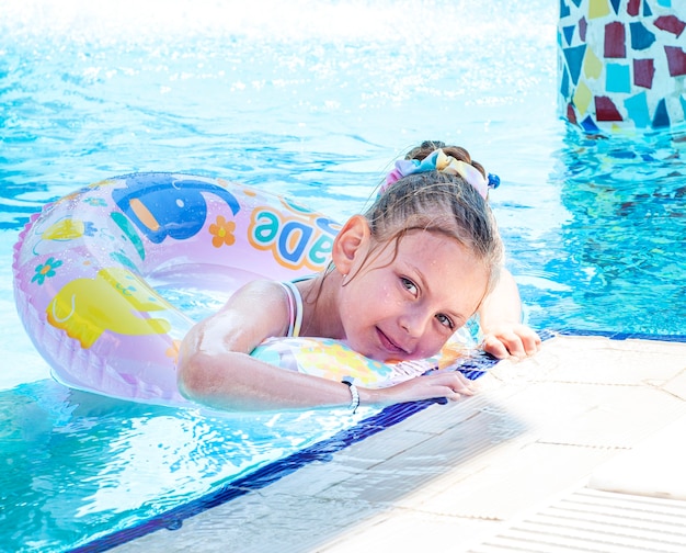 Niña nada con un círculo en la piscina