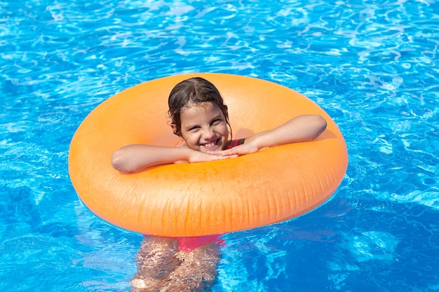 Niña nadando en la piscina en un círculo