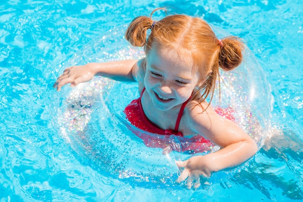 Niña nadando en la piscina en verano