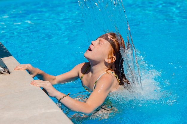 Niña nadando en la piscina en verano