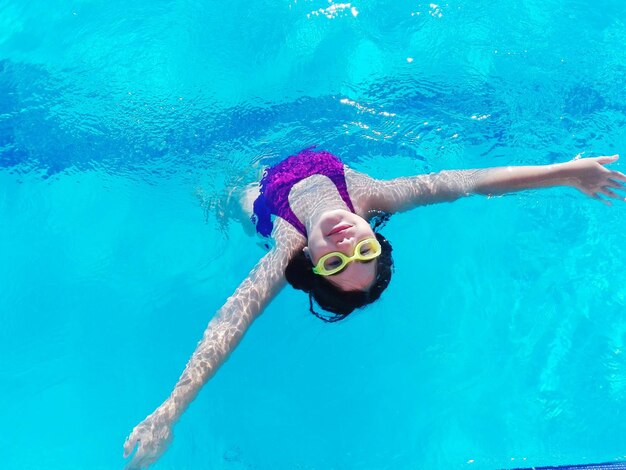 Foto niña nadando en la piscina