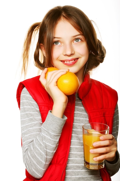 Niña con naranjas y jugo. Aislado en blanco.